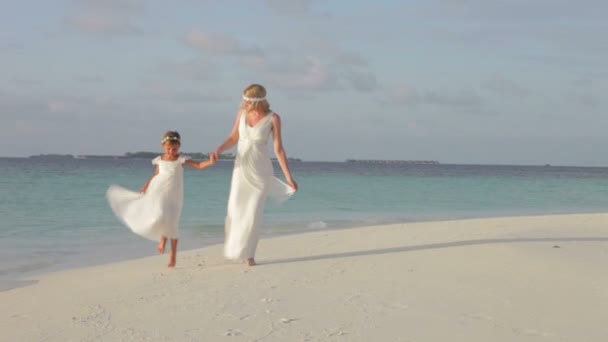 Bride and bridesmaid walk along shore line — Stock Video