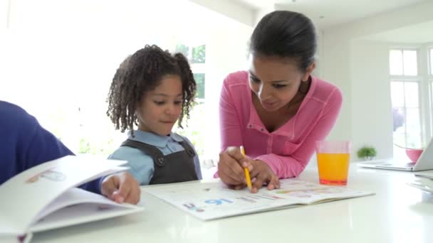 Мама помогает детям с домашним заданием — стоковое видео