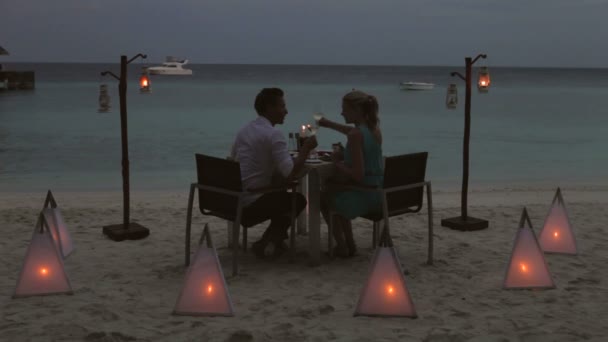 Par njuter av kvällsmåltid på strandrestaurang. — Stockvideo