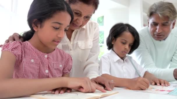 Abuelos ayudando a sus nietos con la tarea — Vídeo de stock