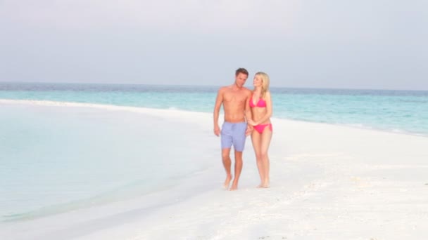 Couple comme ils marchent le long de la plage — Video