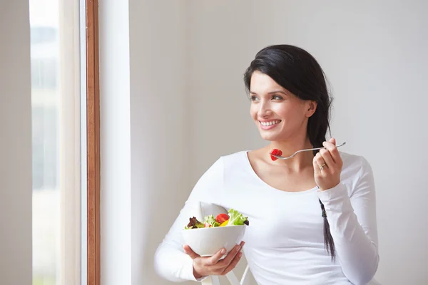 Mulher comendo tigela de frutas frescas — Fotografia de Stock