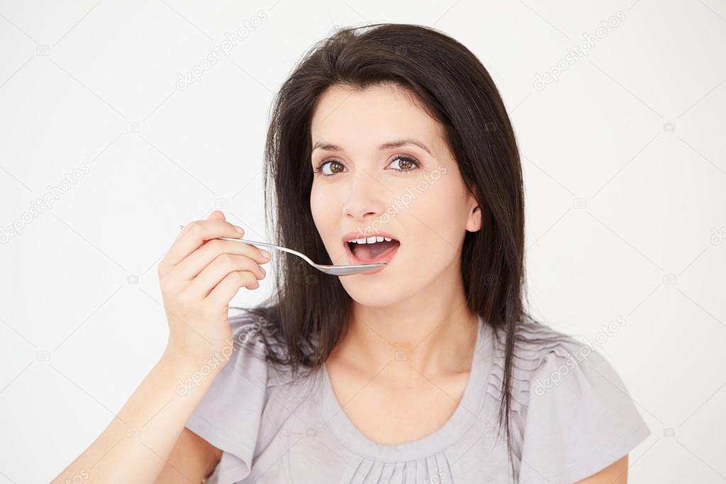 Woman Eating With Spoon Stock Photo By Monkeybusiness