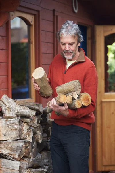 Maduro homem coletando logs para fogo — Fotografia de Stock