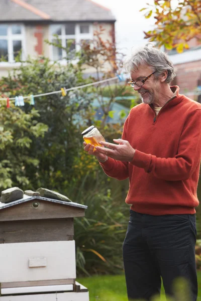 Mature Man Looking At Honey — Stock Photo, Image