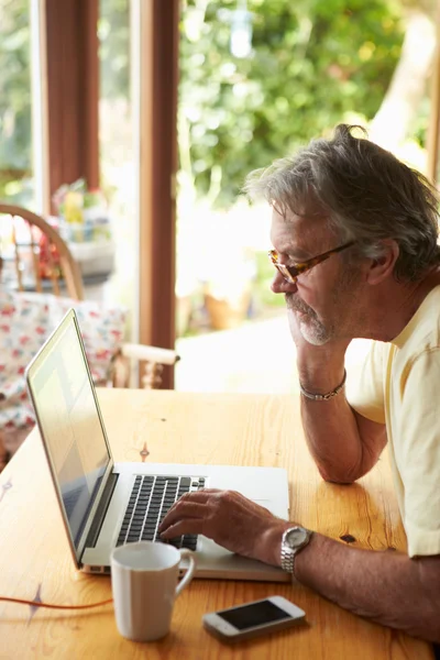 Gammal man som använder bärbar dator — Stockfoto