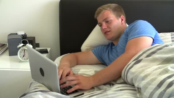 Niño usando el ordenador portátil en la cama — Vídeos de Stock