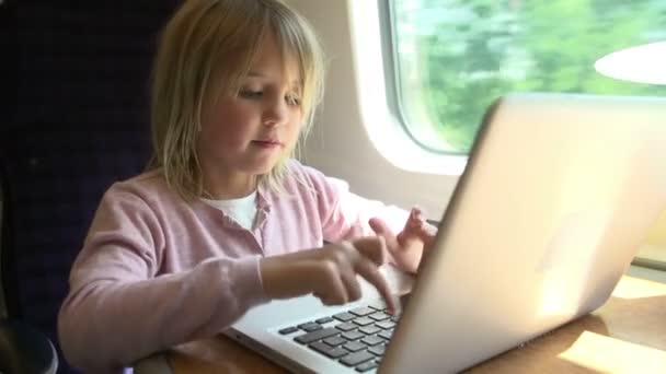 Dziewczyna gra na laptopie w pociągu — Wideo stockowe