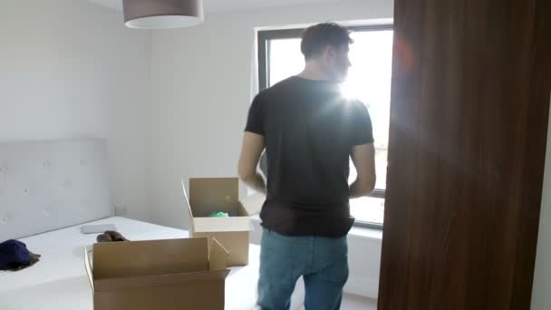 Homem desembalando roupas no quarto — Vídeo de Stock