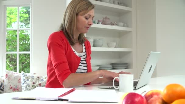 Vrouw met laptop in de keuken — Stockvideo