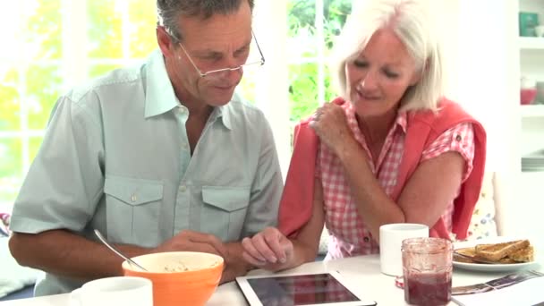Пара глядя на цифровой планшет за завтраком — стоковое видео