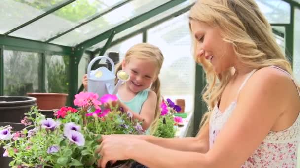 Мати і дочка поливають рослини — стокове відео
