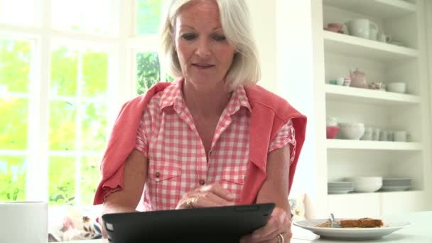 Femme utilisant la tablette numérique pendant le petit déjeuner . — Video