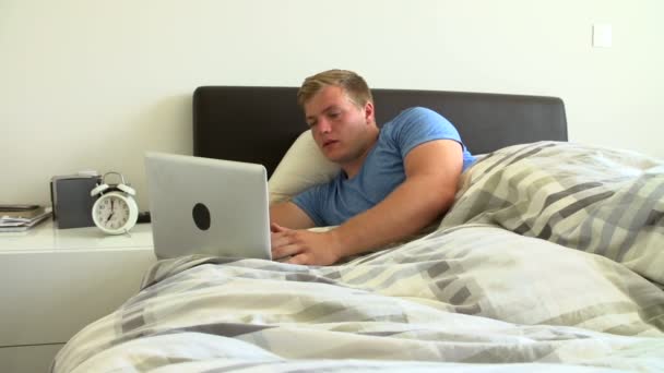Menino deitado na cama usando laptop — Vídeo de Stock