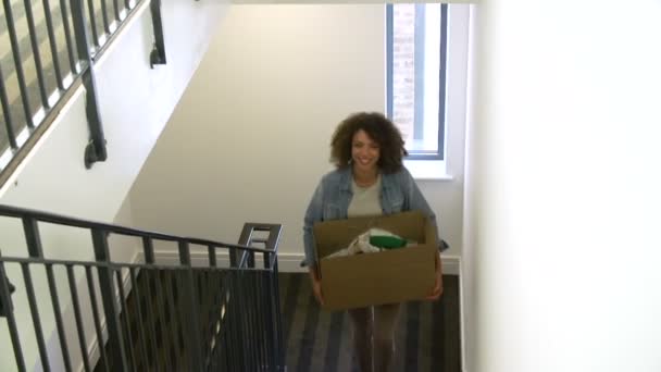 Woman carrying boxes up stairs — Stock video