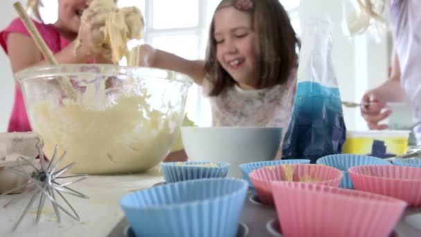 Три маленькие девочки делают торт вместе — стоковое видео