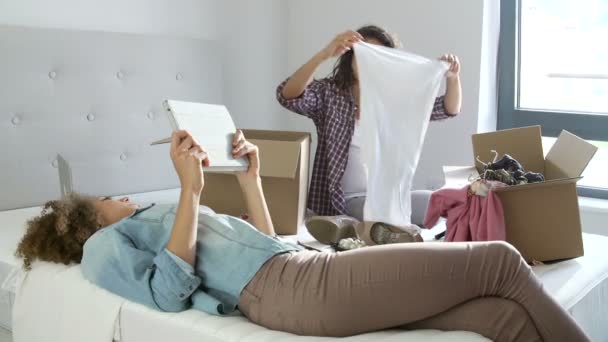 Mujer desempaca ropa en el dormitorio — Vídeos de Stock