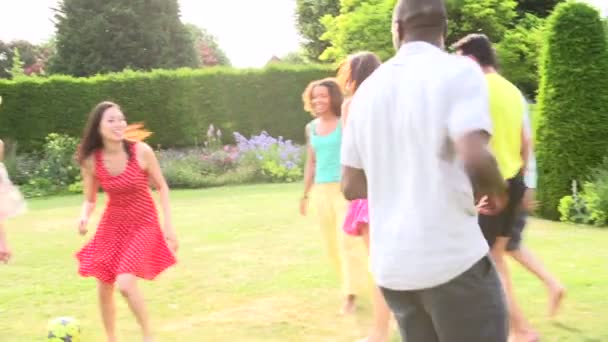 Amigos jugando fútbol en el jardín — Vídeo de stock