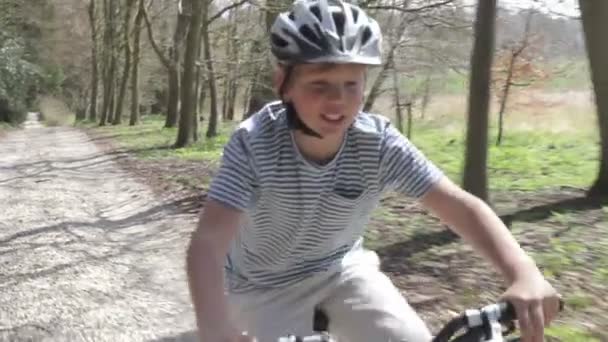 Boy cycling along country lane — Stock Video