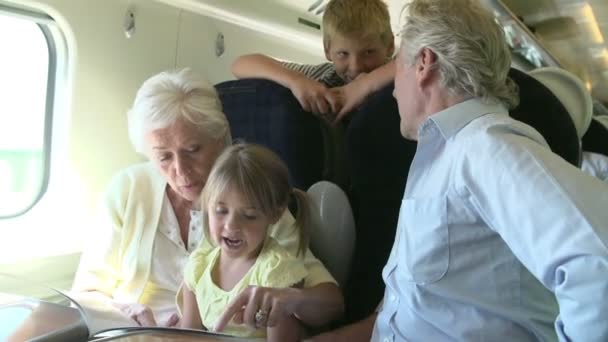 Großeltern nehmen Enkelkinder mit auf Zugfahrt. — Stockvideo