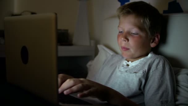 Niño usando el ordenador portátil en la noche — Vídeos de Stock