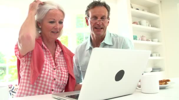 Pareja mirando a la computadora portátil durante el desayuno — Vídeo de stock