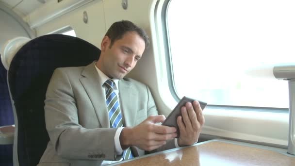 Бизнесмен смотрит на электронного читателя в поезде — стоковое видео