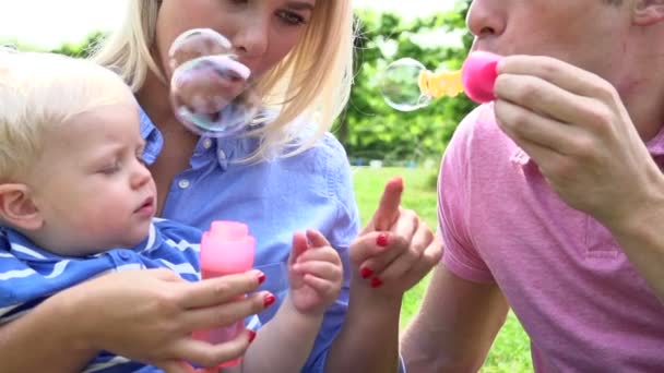Отец надувает пузырьки для младенца — стоковое видео