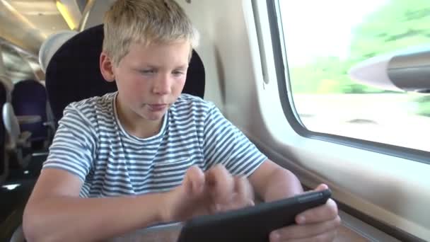 Мальчик, читающий E Book On Train Journey — стоковое видео