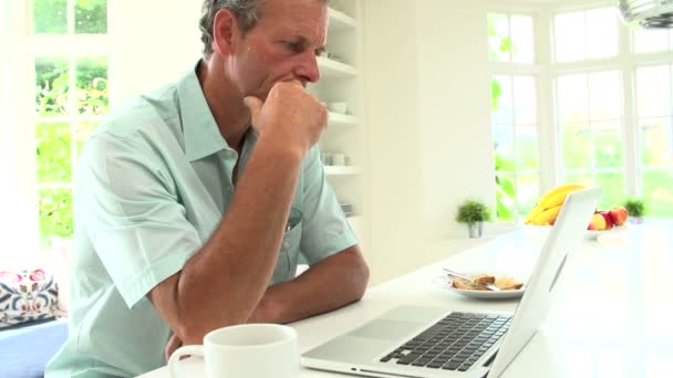 Mann benutzt Laptop und frühstückt — Stockvideo