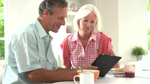 Casal olhando para tablet digital durante o café da manhã — Vídeo de Stock