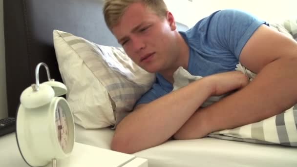 Мальчик в кровати выключает часы — стоковое видео
