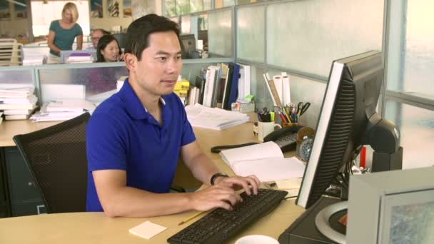 Hombre trabajando en la computadora en la oficina — Vídeos de Stock