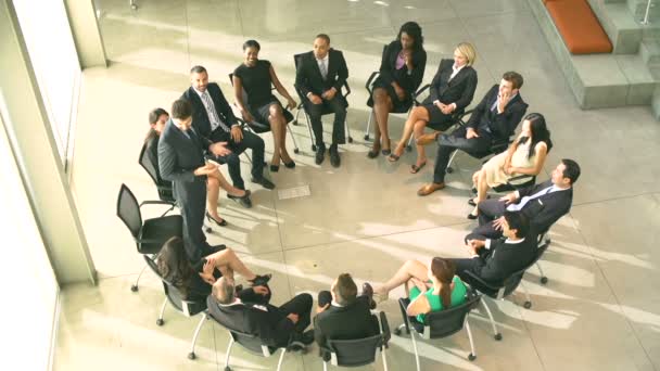Бизнесмены сидят в кругу на стульях — стоковое видео