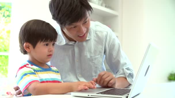 Padre trabajando en el ordenador portátil con el hijo — Vídeo de stock