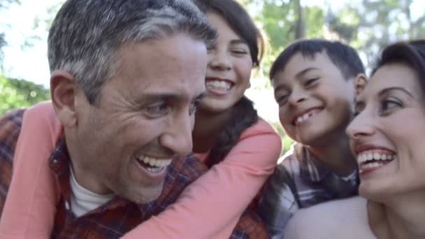 Padres dando paseo a los niños a cuestas — Vídeo de stock