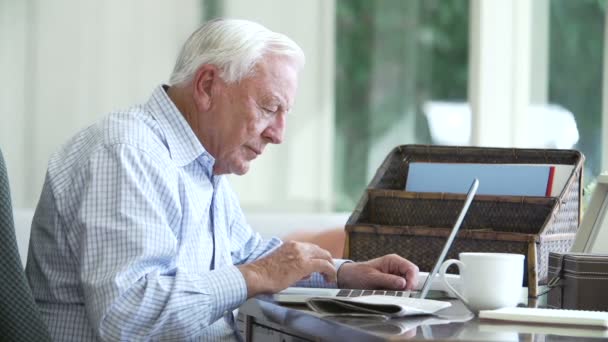 Starší muž pomocí přenosného počítače — Stock video