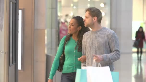 Pareja mirando en el centro comercial tienda ventanas — Vídeo de stock