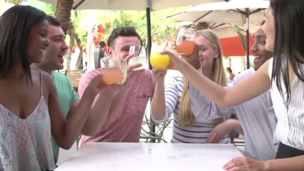 Група друзів насолоджуючись напоями у відкритому ресторані — стокове відео