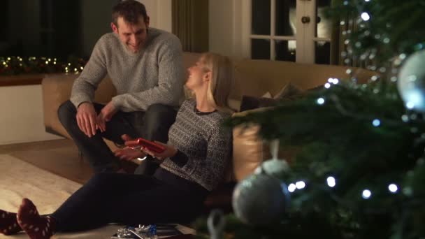 Pareja intercambiando regalos en el sofá — Vídeos de Stock
