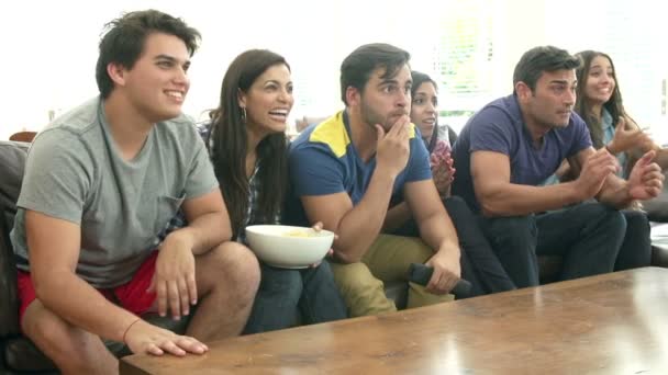 Grupo de amigos sentados en el sofá viendo televisión juntos — Vídeos de Stock