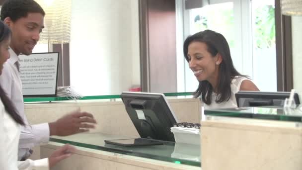 Casal de check-in na recepção do hotel usando tablet digital — Vídeo de Stock
