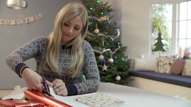 Женщина упаковывает рождественские подарки — стоковое видео