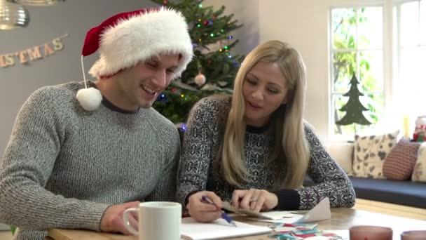 Paar schrijven kerstkaarten — Stockvideo