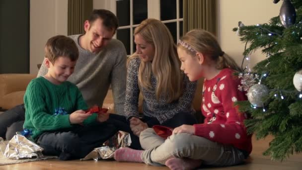 Familie uitpakken geschenken door kerstboom — Stockvideo