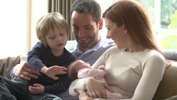 Familie sitzt mit Neugeborenem auf Sofa — Stockvideo