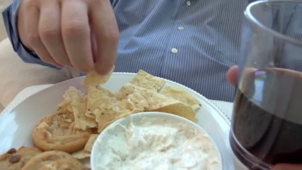 Человек с избыточным весом дома ест закуски и смотрит телевизор — стоковое видео