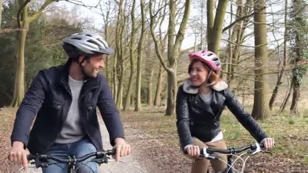 Pareja en paseo en bicicleta en campo de invierno — Vídeo de stock