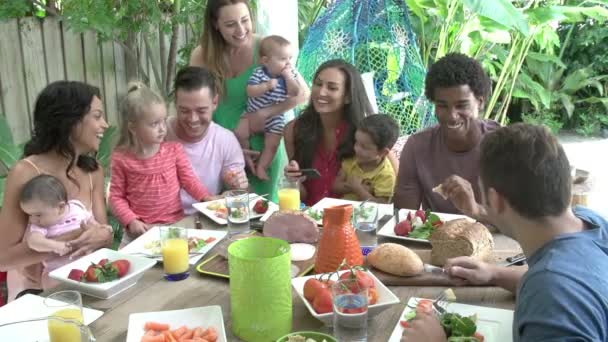 Ομάδα των οικογενειών απολαμβάνοντας υπαίθριο γεύμα στο σπίτι — Αρχείο Βίντεο