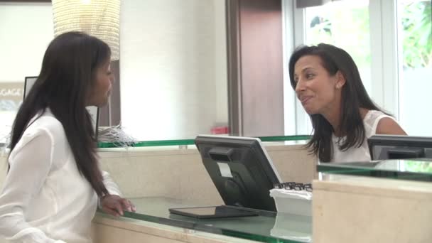 Mujer registrándose en la recepción del hotel usando tableta digital — Vídeo de stock